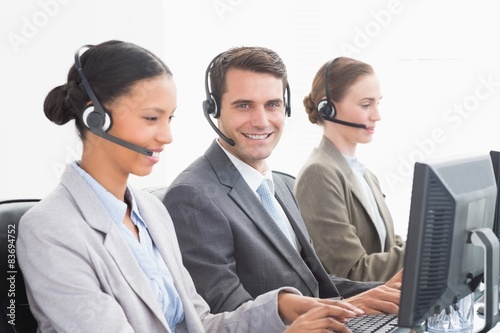 Business people with headsets using computers 