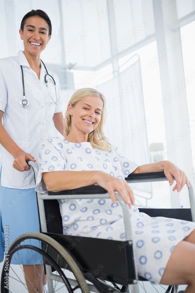 Doctor and patient in wheelchair smiling at camera Doctor and patient in wheelchair smiling at camera