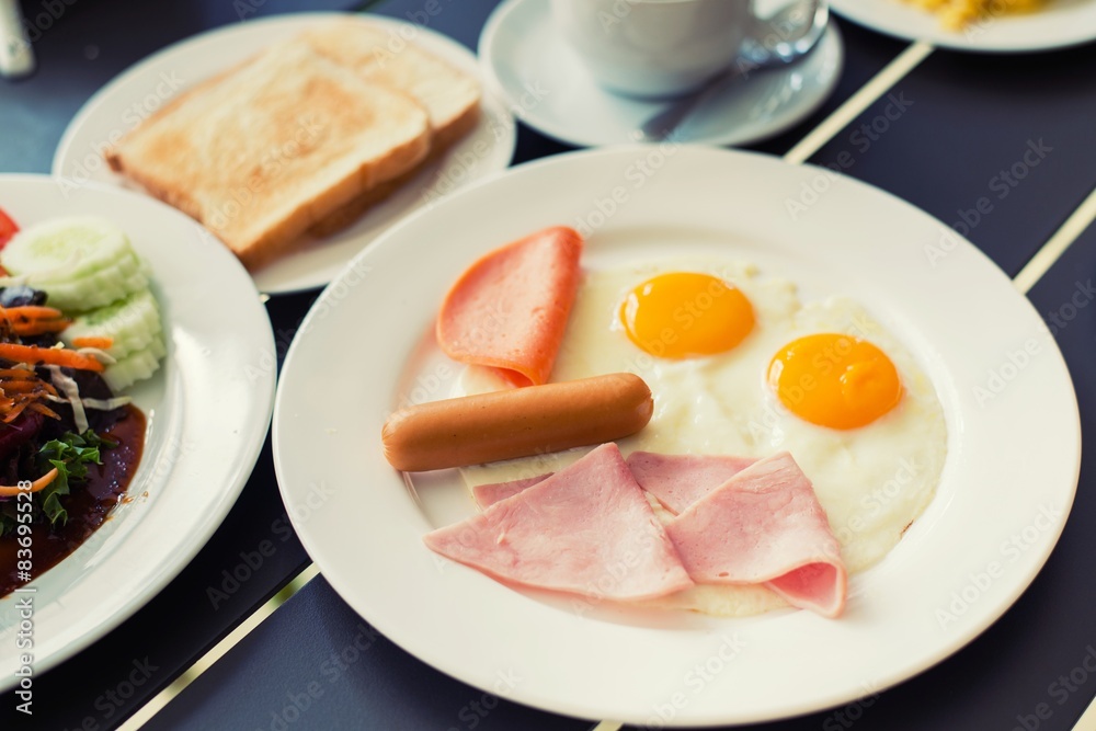 Ham breakfast served with coffee, toast and salads that taste go