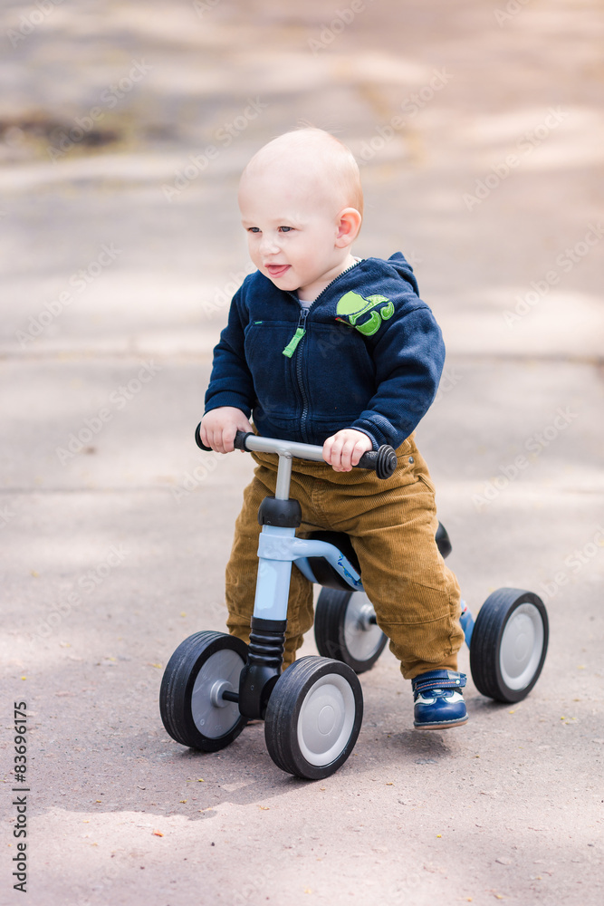 Cute baby boy on his first running bike Cute baby boy on his first running bike