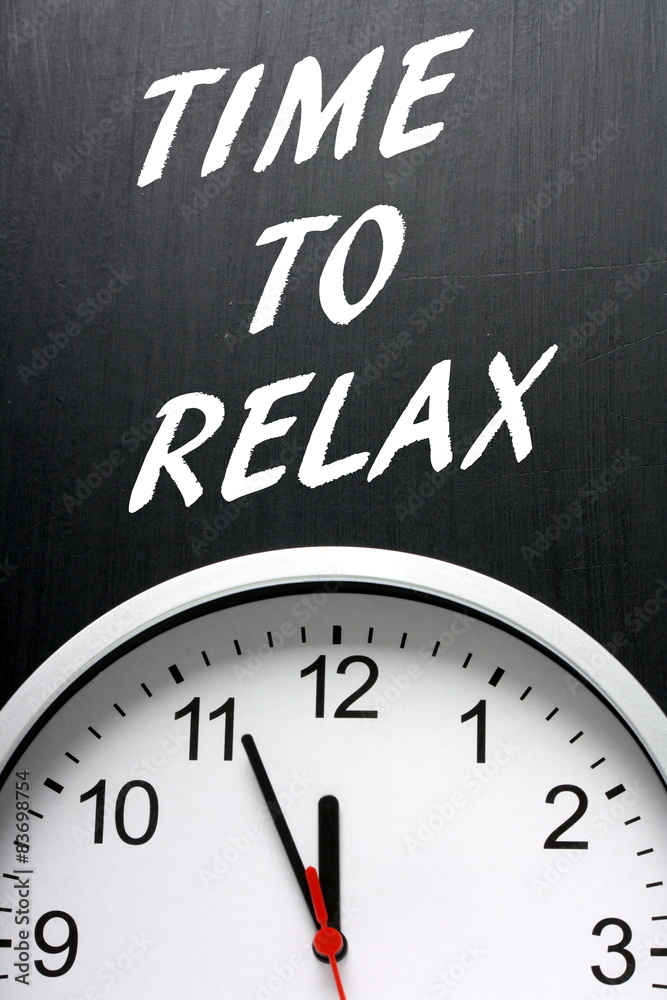 Time To Relax on a blackboard above a modern clock Time To Relax on a blackboard above a modern clock
