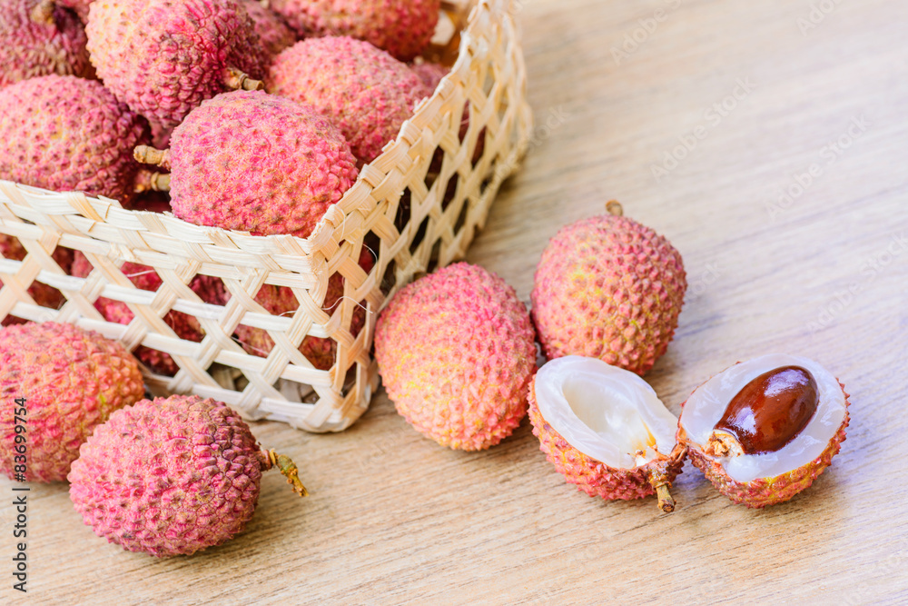 Fresh lychee in bamboo basket on a wooden background Fresh lychee in bamboo basket on a wooden background