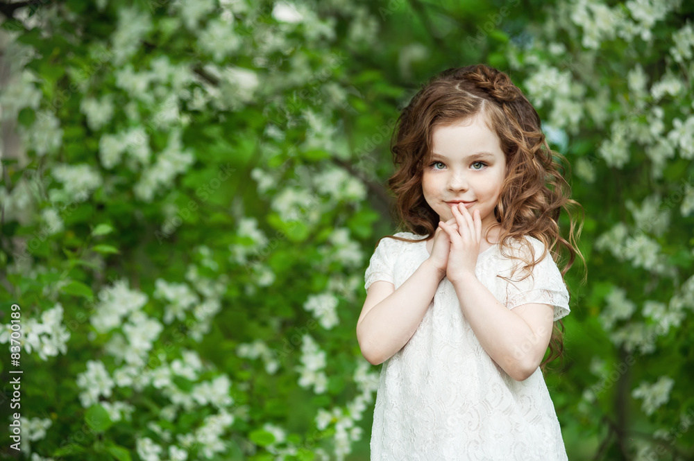 Portrait beautiful little girl near blossoming apple-tree Portrait beautiful little girl near blossoming apple-tree