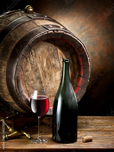 Still-life with glass of wine, bottle and barrel. photo