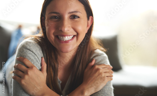 Tableau sur toile Woman laying on couch smiling widely.