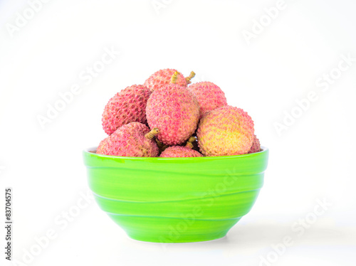 Ripe lychee fruit in green bowl against white background photo