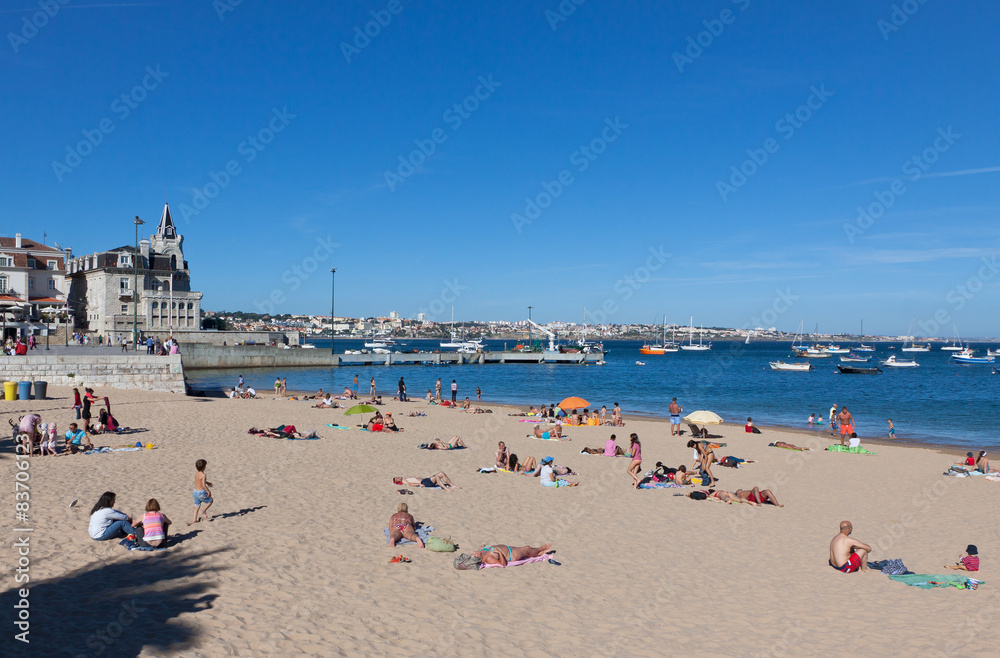 People sunbathing on the beach in Cascais, Portugal
