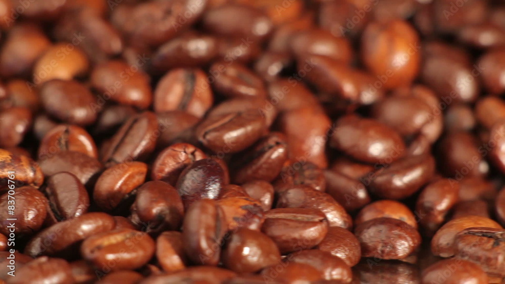 Roasted coffee beans rotates on the table. close-up Roasted coffee beans rotates on the table. close-up