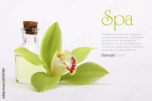 Spa concept. Green orchid and spa oil, isolated on white.