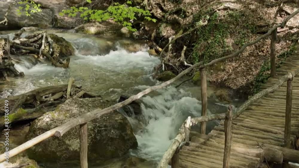 Old Wooden Bridge Over a Mountain Stream Flowing in the Canyon Old Wooden Bridge Over a Mountain Stream Flowing in the Canyon