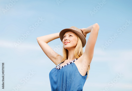 girl in hat standing on the beach