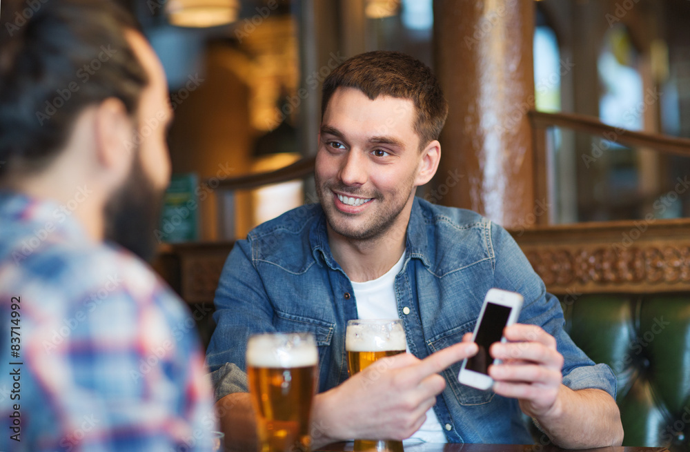 male friends with smartphone drinking beer at bar male friends with smartphone drinking beer at bar