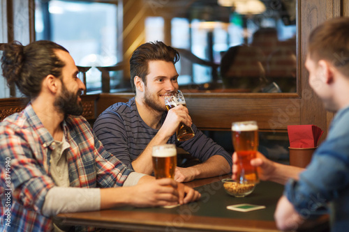 Sticker happy male friends drinking beer at bar or pub