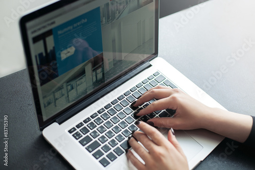 Shot of a young woman working with laptop, woman's hands using