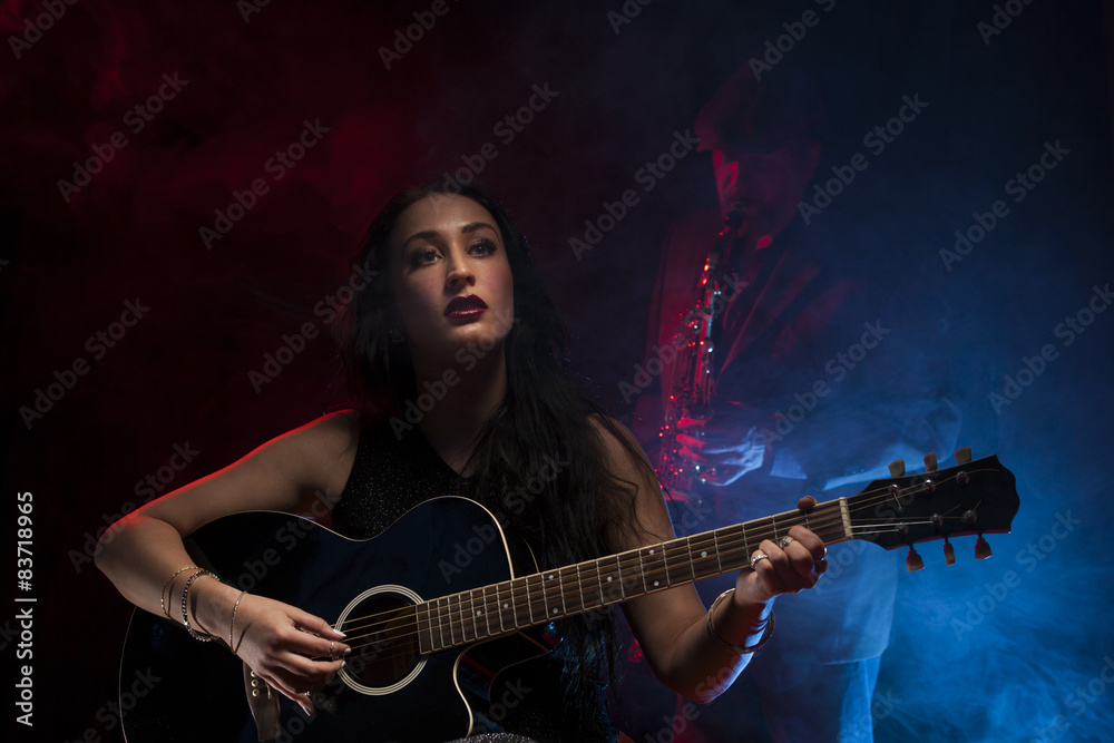 Lady guitarist with a saxophonist