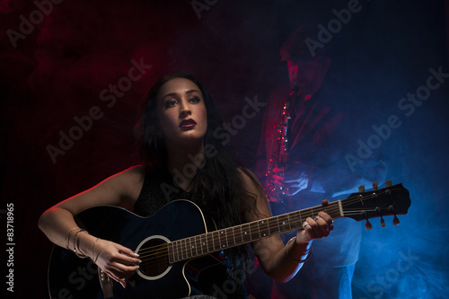 Lady guitarist with a saxophonist
