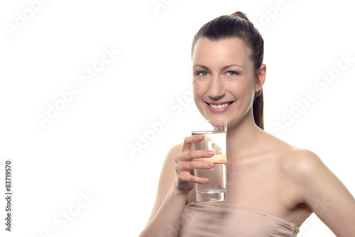 Lächelnde gesunde Frau trinkt ein Glas Wasser