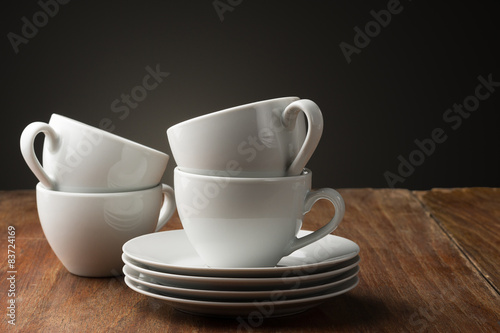 Four plain white ceramic coffee cups
