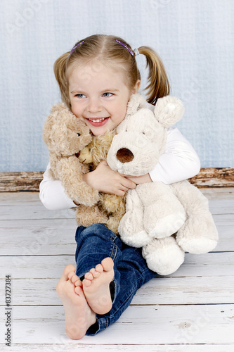 Fotografía Little girl cuddling with plush toys