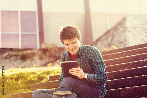 Young smiling student  outdoors  with tablet.Life style.City