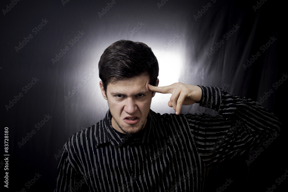 Aggressive portrait of man,pointing with finger to his had