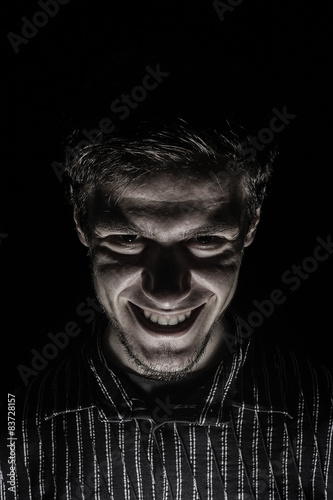 Man portrait with evil look isolated on black background.