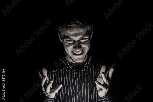 Man portrait with evil look isolated on black background.