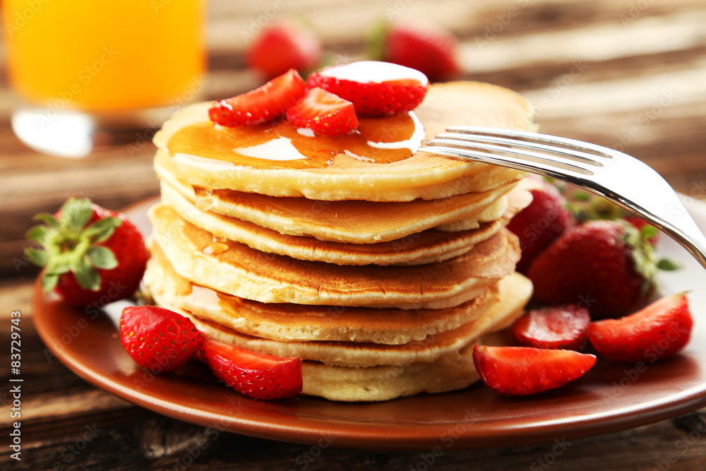 Delicious pancakes with strawberry on brown wooden background Delicious pancakes with strawberry on brown wooden background