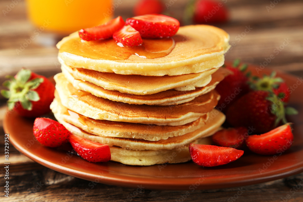 Delicious pancakes with strawberry on brown wooden background Delicious pancakes with strawberry on brown wooden background