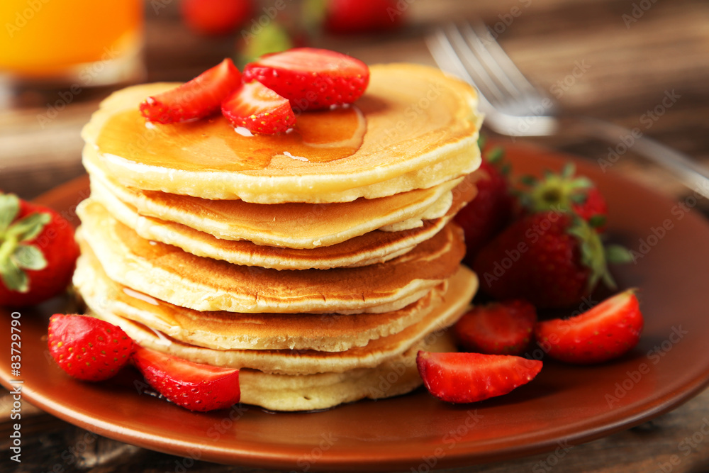 Delicious pancakes with strawberry on brown wooden background Delicious pancakes with strawberry on brown wooden background