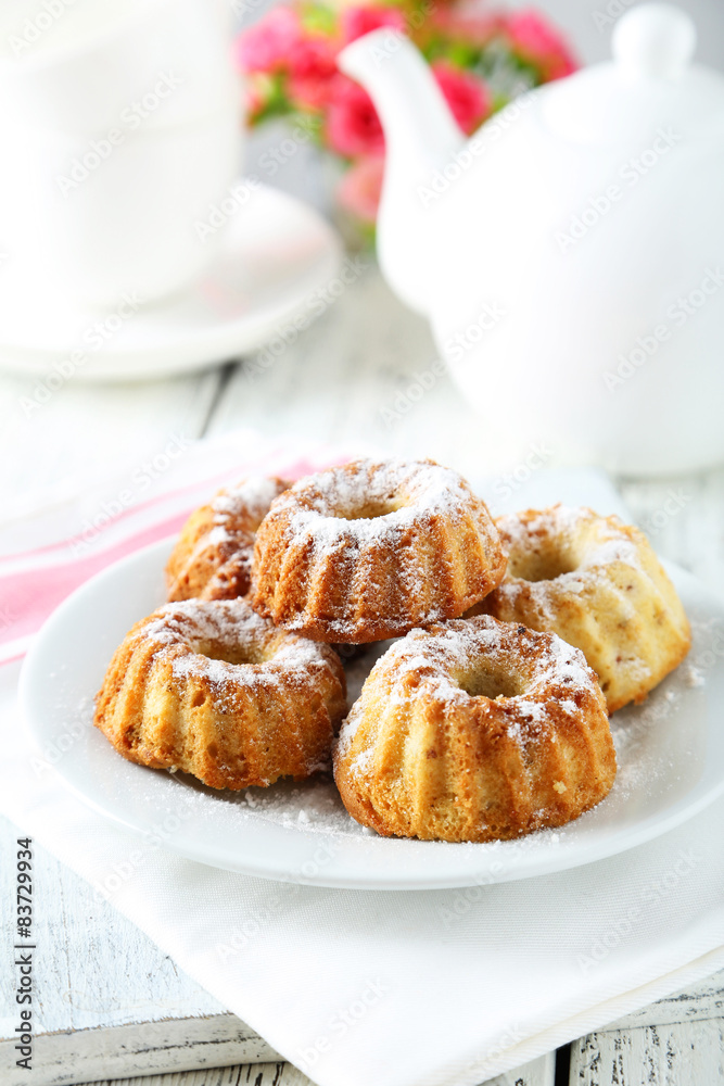 Bundt cakes on plate on white wooden background Bundt cakes on plate on white wooden background