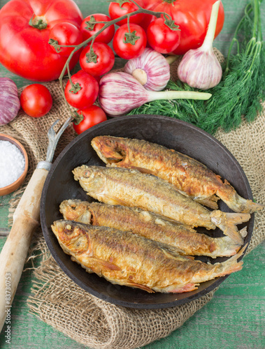 Fried fish and vegetables on the table. Rustic style