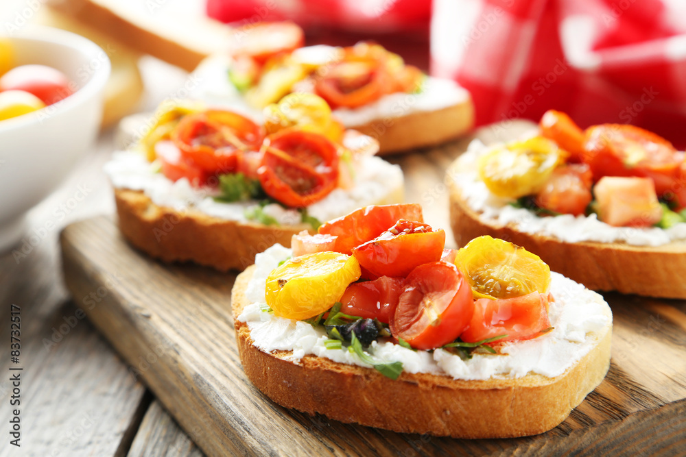 Tasty fresh bruschetta with tomatoes on cutting board on grey wo