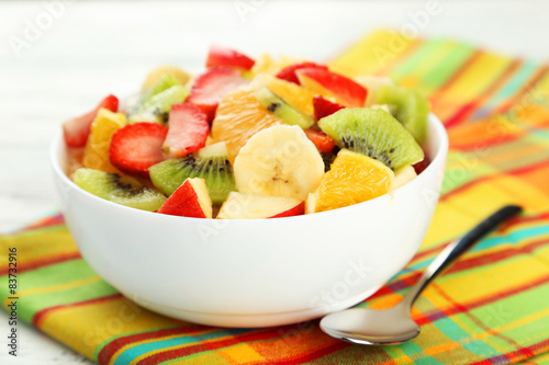 Fresh fruit salad on white wooden background