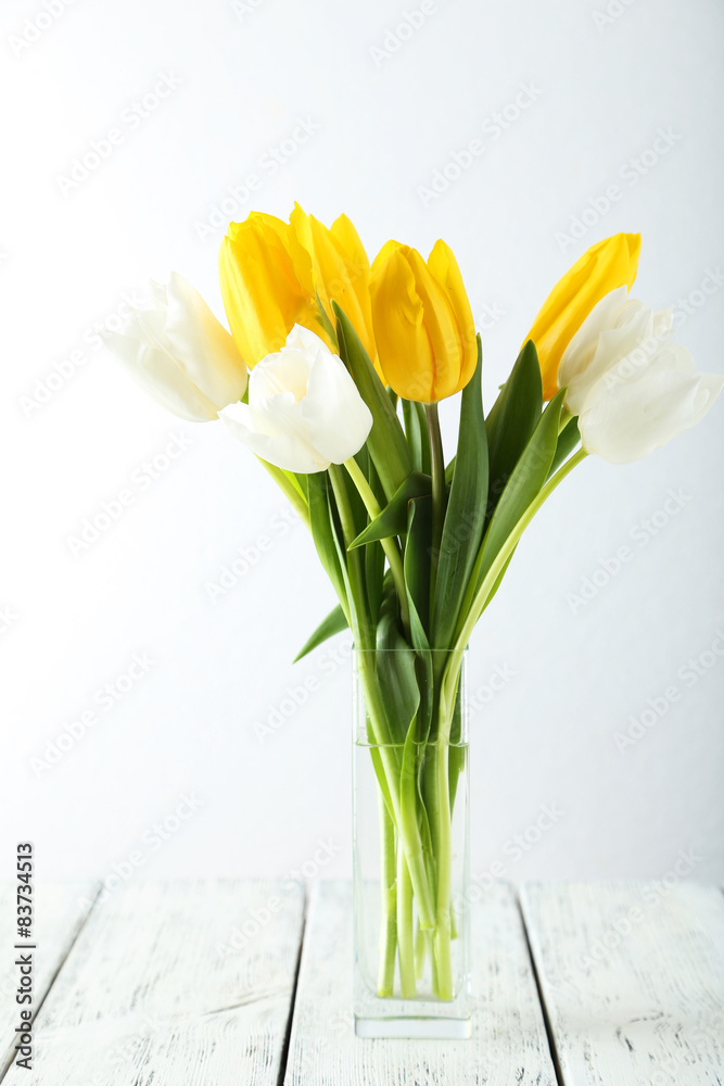 Beautiful tulips in vase on white wooden background Beautiful tulips in vase on white wooden background