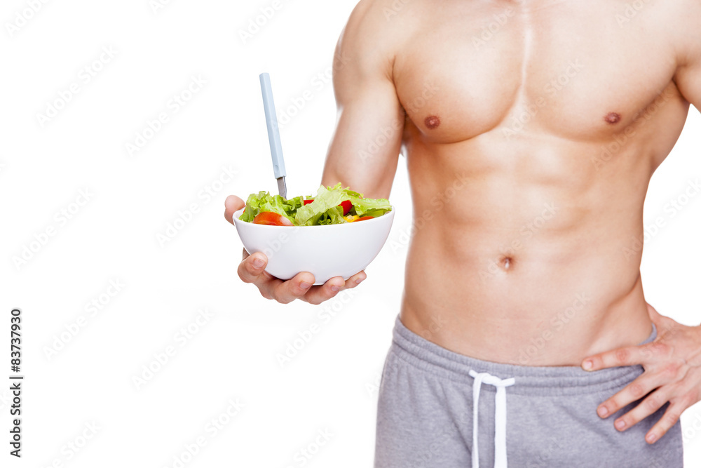 Muscular man holding a bowl of salad, isolated on white backgrou Muscular man holding a bowl of salad, isolated on white backgrou