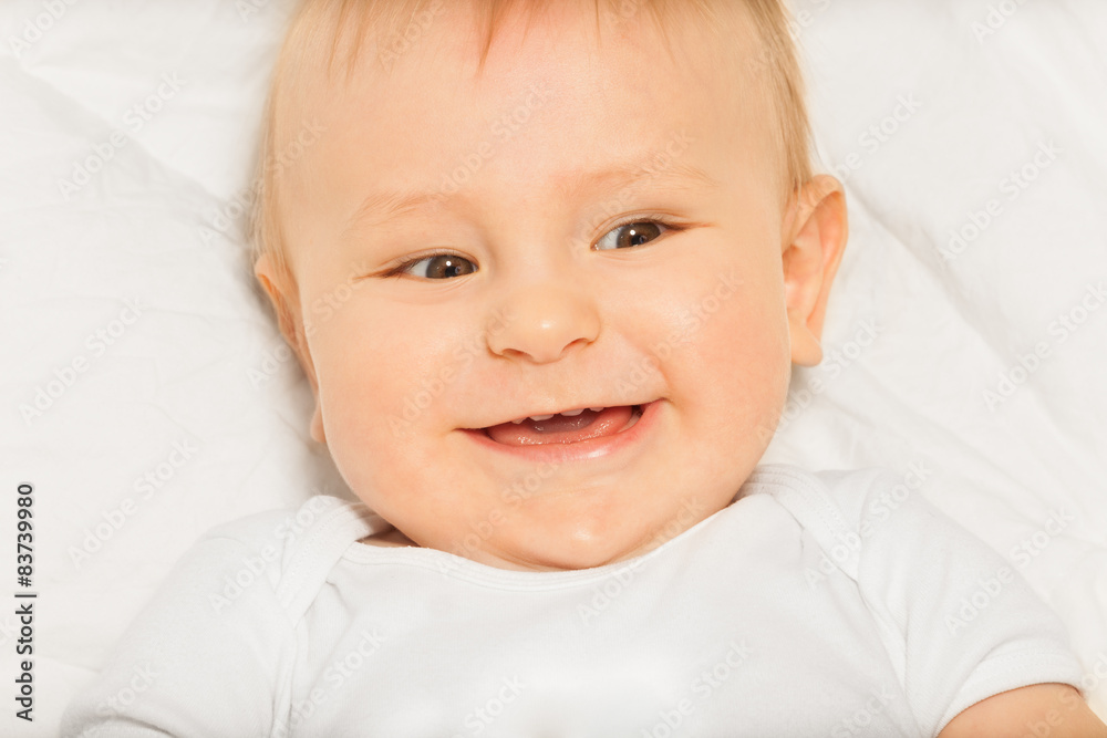 Happy face of small baby wearing white bodysuit 