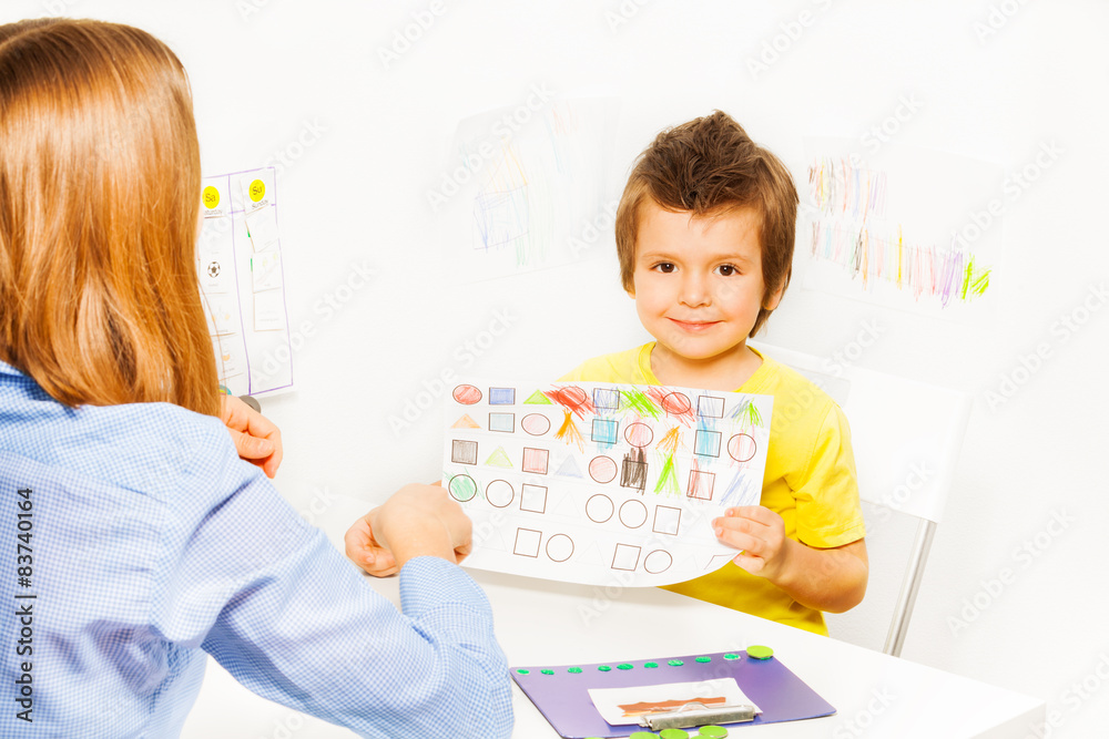 Cute boy holding the drawing with colored shapes Cute boy holding the drawing with colored shapes