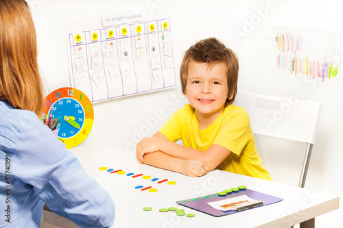 Smiling boy with colorful coins in order