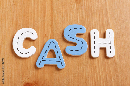 CASH, spell by woody puzzle letters with woody background