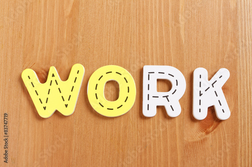 WORK, spell by woody puzzle letters with woody background