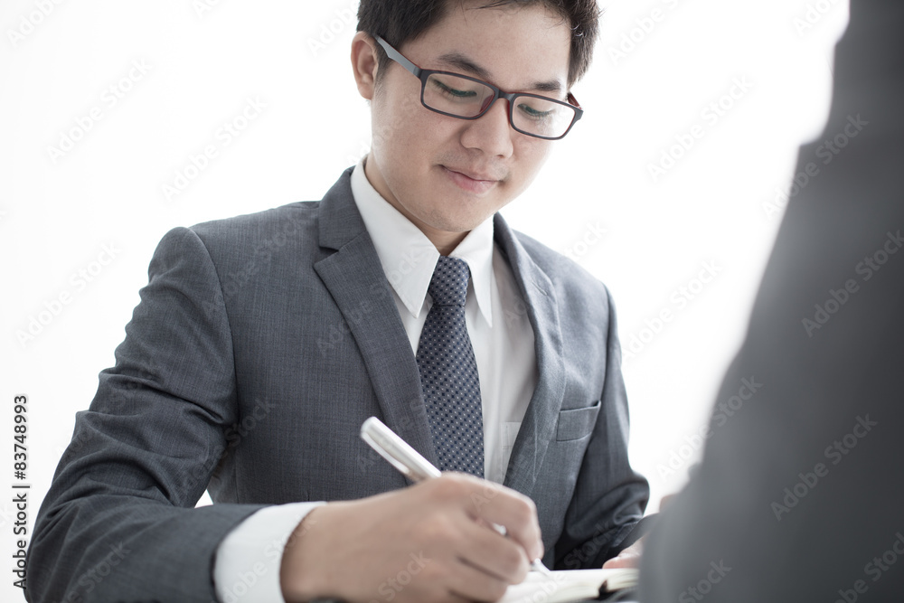 Two businessmen looking at report and having a discussion in off