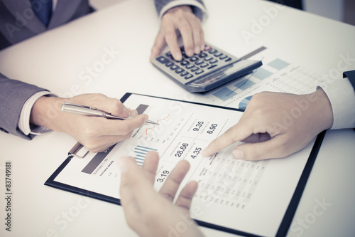 Two businessmen looking at report and having a discussion in off