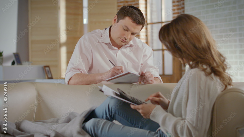 Serious young couple planning family budget, calculating costs Serious young couple planning family budget, calculating costs