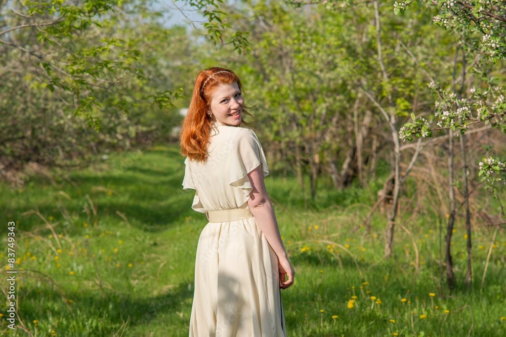 beautiful red-haired girl walks in apple orchard beautiful red-haired girl walks in apple orchard