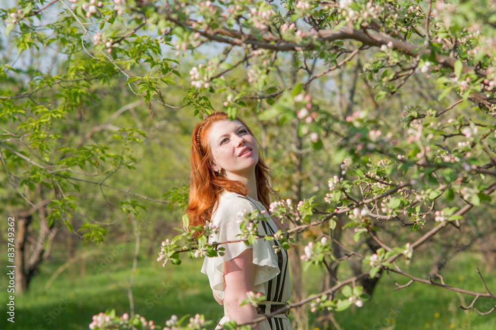 beautiful red-haired girl walks in apple orchard beautiful red-haired girl walks in apple orchard