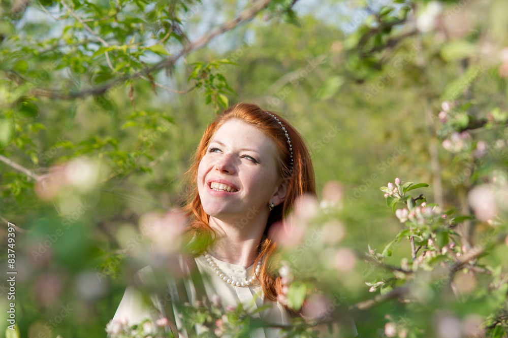 beautiful red-haired girl walks in apple orchard beautiful red-haired girl walks in apple orchard