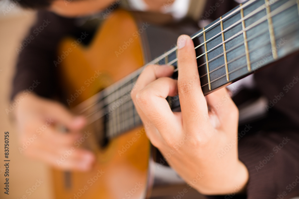 Obraz premium Praktyka gry na gitarze. Przystojni młodzi mężczyźni grający na gitarze