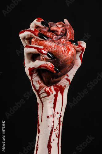 bloody hands with black nails holding bloody human heart © Parad St
