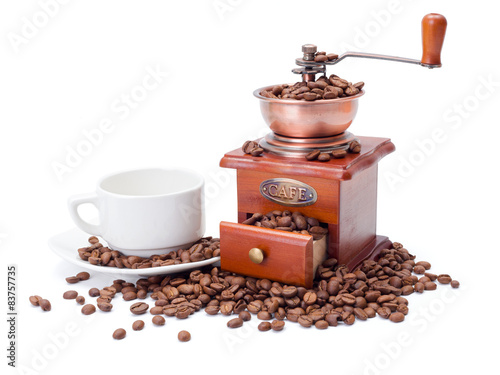 Old fashioned coffee ginder with cup and beans